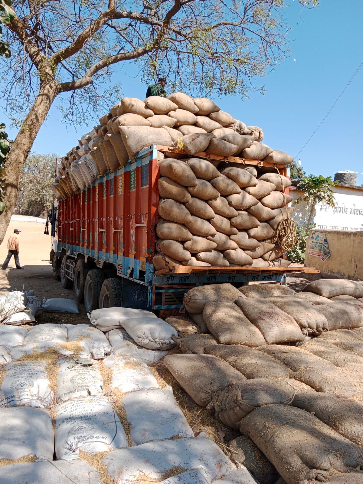 A lorry loaded high with sacks at a roadside yard in Bagbahara, Chhattisgarh
